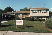 Stock Photo of 1960S Split Level Ranch House Home With For Sale Sign