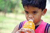 Young kid drinking mango juice - x13345496